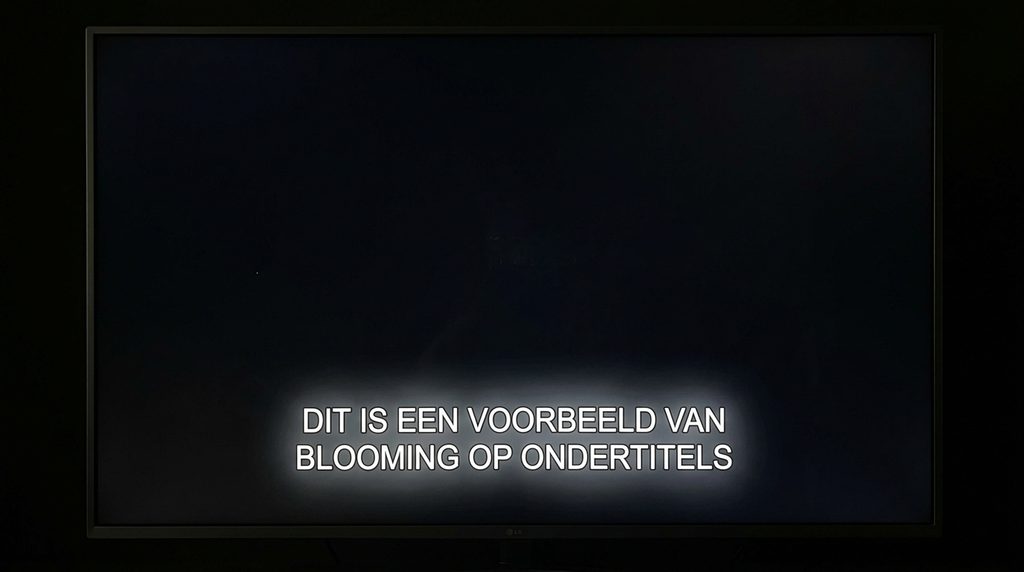Voorbeeld van blooming rond witte ondertitels op een donkere achtergrond als uitleg bij de vraag: wat is blooming?